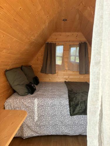 une chambre avec un lit dans une cabane en bois dans l'établissement La Cabane Mini Enchantée !, à Thenay