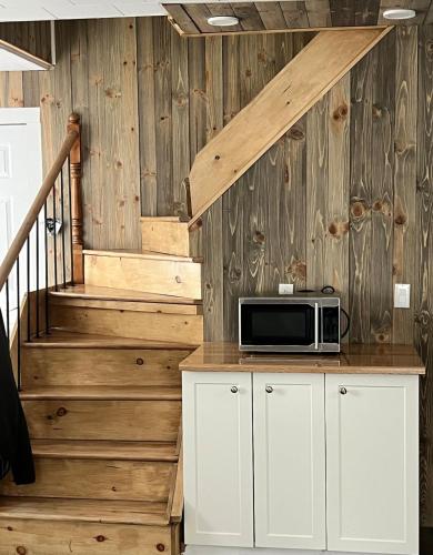 a microwave sitting on top of a counter next to a staircase at Homefeel Stylish Modern House in Chambord