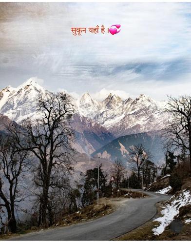 a road in front of mountains with a pink object in the air at Ma Kokila Homestay in Munsyari