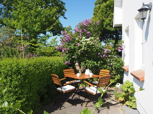 a table and chairs in a garden with flowers at Lieblingsplatz im Reethus in Putbus