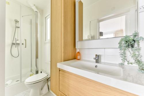 une salle de bain avec un lavabo, des toilettes et un miroir dans l'établissement Quiet & Refurbished 1BR Parisian Retreat-Paris 16, à Paris
