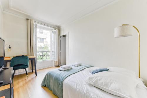 une chambre avec un lit, un bureau et une fenêtre dans l'établissement Quiet & Refurbished 1BR Parisian Retreat-Paris 16, à Paris