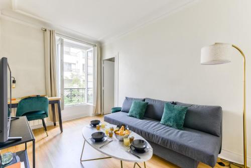 un salon avec un canapé et une table dans l'établissement Quiet & Refurbished 1BR Parisian Retreat-Paris 16, à Paris