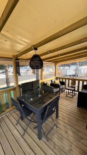 un patio avec une table et des chaises sur une terrasse dans l'établissement Mobil home 3 chambres 40 m2, à Quiberon