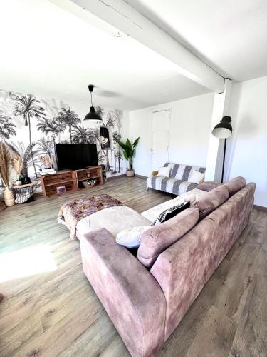 un salon avec un canapé et une télévision dans l'établissement Maison 300m de la plage, à Andernos-les-Bains