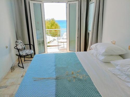 a bedroom with a bed with a view of the ocean at Phil Samosflats Beachfront Maisonettes in Potokáki