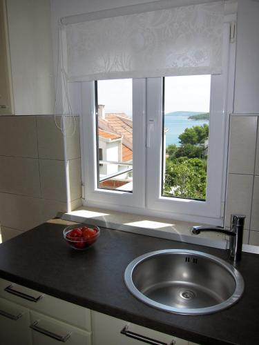 a kitchen sink with a window and a bowl of fruit at Apartment 2 Palme in Slatine