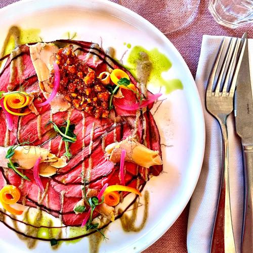 a plate of food with meat and vegetables on a table at Chamois Lodge in Les Deux Alpes
