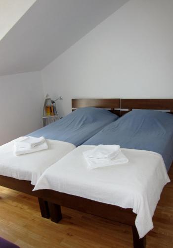 two beds in a bedroom with white sheets at Apartment 2 Palme in Slatine