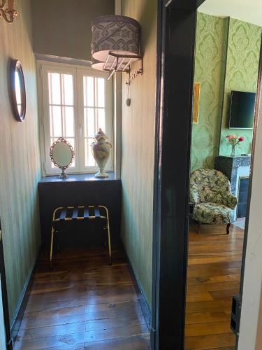 a hallway with a chair and a window at Maison de l'Aumance in Meaulne
