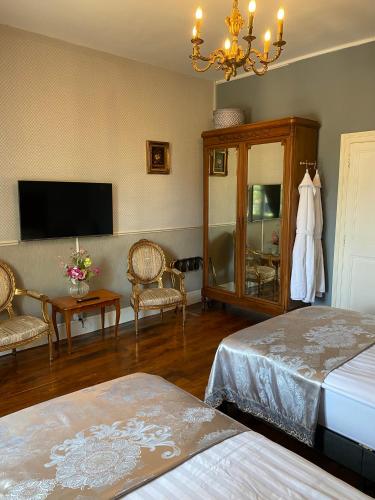 a bedroom with two beds and a flat screen tv at Maison de l'Aumance in Meaulne