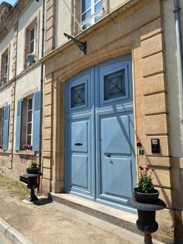 a blue garage door on the side of a building at Maison de l'Aumance in Meaulne