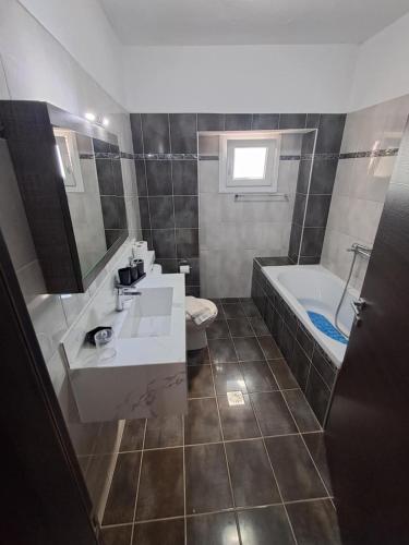 a bathroom with a sink and a tub and a toilet at Soti's House in Kallirákhi