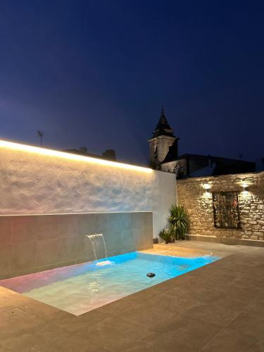 a swimming pool in front of a building at night at El Rincón de la Villa in Sabiote