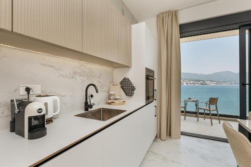 a kitchen with a sink and a view of the ocean at Njivice Coastal Oasis in Njivice