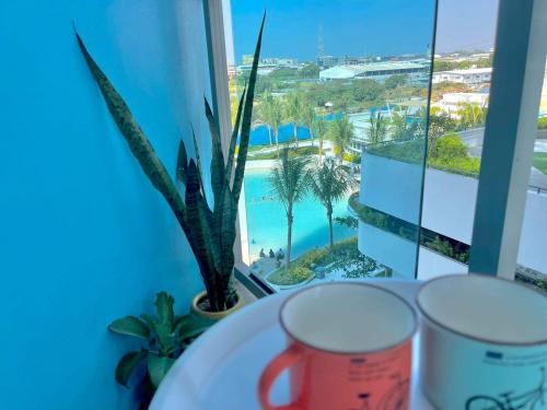 a table with two cups and a view of a pool at K Place Staycation at Azure North in San Fernando