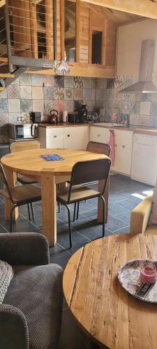 a kitchen with a wooden table and chairs in a room at la cabane de chez berthe proche de la plage in Chaucre