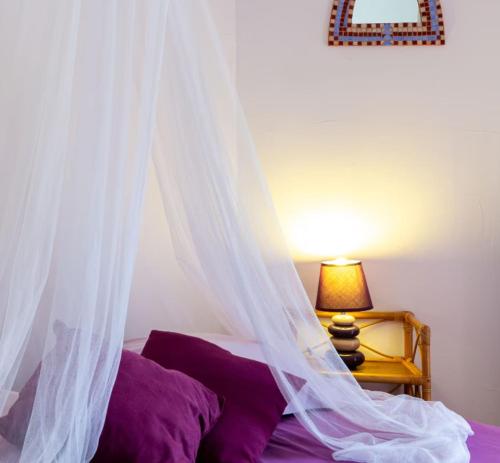 a bedroom with a bed with a mosquito net at Les Planious in LʼÉpine