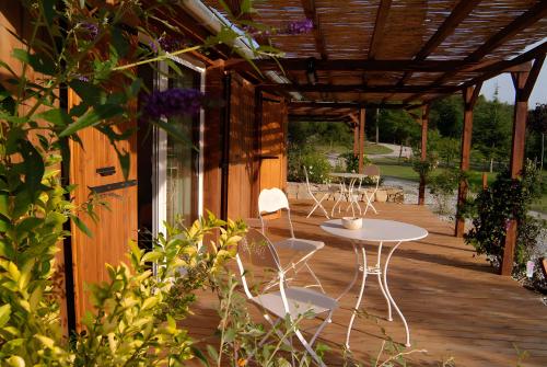 a patio with a table and chairs on a wooden deck at Les Planious in LʼÉpine