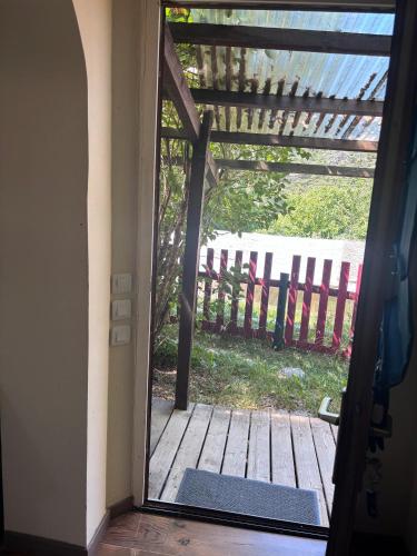 an open door to a deck with a fence at Les Planious in LʼÉpine