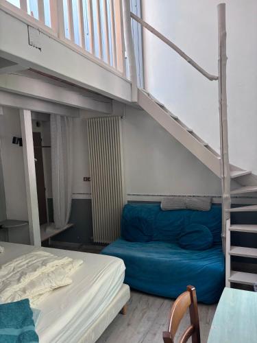 a bedroom with a bunk bed and a blue couch at Les Planious in LʼÉpine