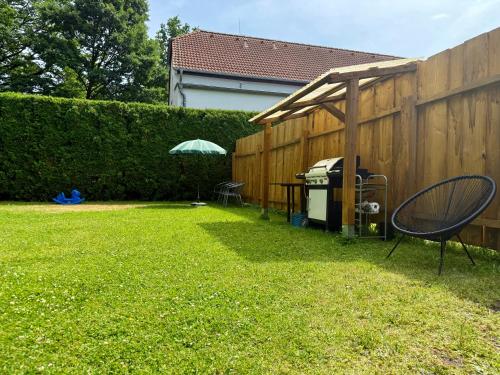 a backyard with a table and an umbrella and a fence at Penzion U zámeckého parku in Třeboň