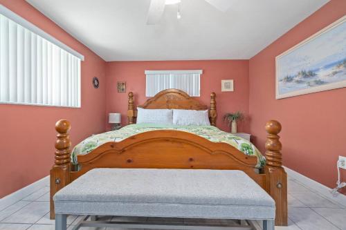 a bedroom with a wooden bed with orange walls at Boaters Dream Rustic Waterfront Retreat in New Port Richey