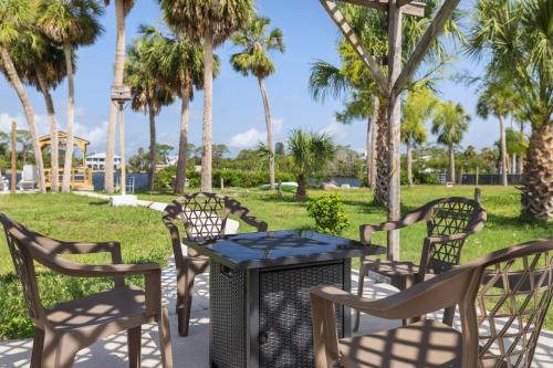 a table and chairs in a park with palm trees at Boaters Dream Rustic Waterfront Retreat in New Port Richey