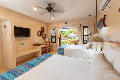 a bedroom with two beds and a television at Kalimera Beach Hotel in Maya Beach