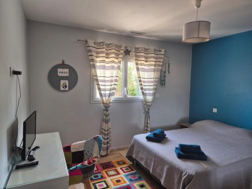 une chambre avec deux lits, un bureau et une télévision dans l'établissement Maison moderne avec spa Le Bosc Salagou, à Le Bosc