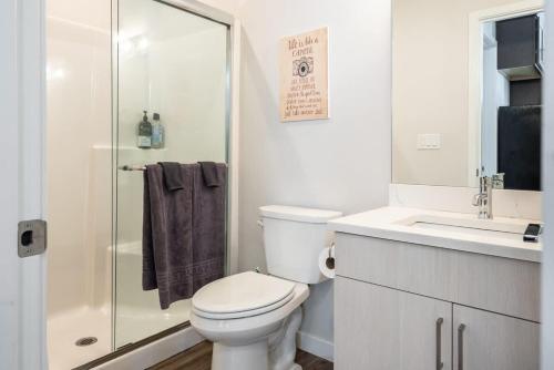 a white bathroom with a toilet and a shower at Walkable Apt Next to Restaurants, Bars, and Shops! in Portland