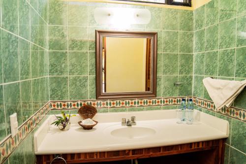 a bathroom with a sink and a mirror at Banana Palms Hotel in Rio Dulce
