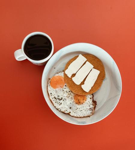 a plate of food with eggs and a cup of coffee at Hotel Santa Ana Medellin in Medellín