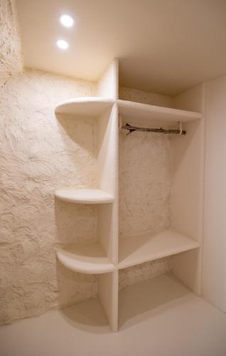a walk in closet with white shelves in a room at CASA ANANTA Appartements bien-être aux portes du Verdon Refuge slow Life et sensoriel jusqu à 12 pers in La Garde