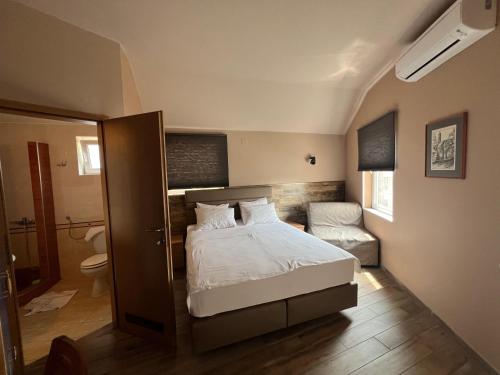 een kleine slaapkamer met een bed en een badkamer bij Vila Lago in Veliko Gradište