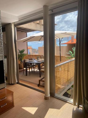 a living room with a sliding glass door with a dining table at Casa Reina in Playa Jandia