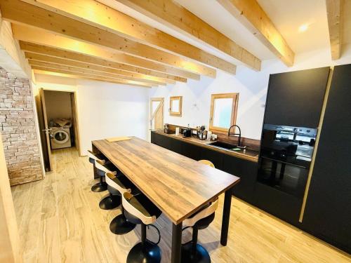 une cuisine avec une table en bois et quelques chaises dans l'établissement MAGNIFIQUE CHALET 3 CHAMBRES CONSTRUCTION NEUVE, à Beuil