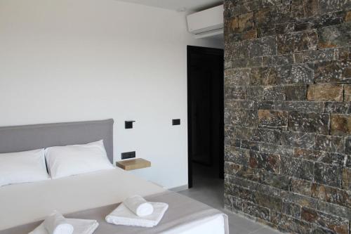 a bedroom with a bed and a brick wall at Astrokastro Seaside Residence in Frangokastello