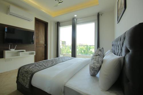 a bedroom with a large bed with a large window at Reebah Inn & Suites in Gurgaon