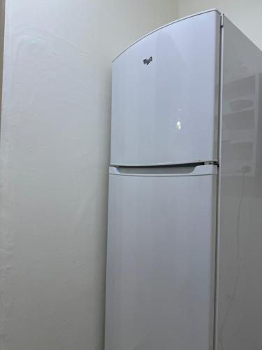 a white refrigerator is standing next to a wall at Only 5-minutes walk to airport, your perfect choice for an early or late flight in Oulad Akkou