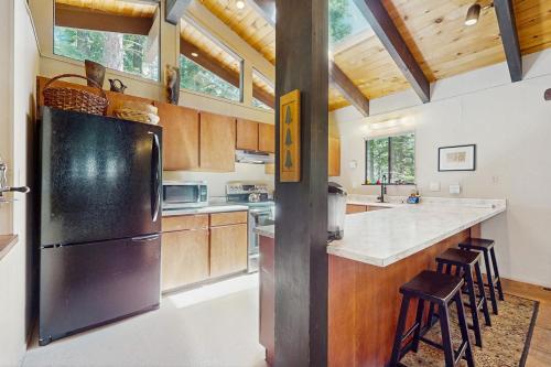 a kitchen with a stainless steel refrigerator and wooden cabinets at Simplon Pass Escape in Homewood