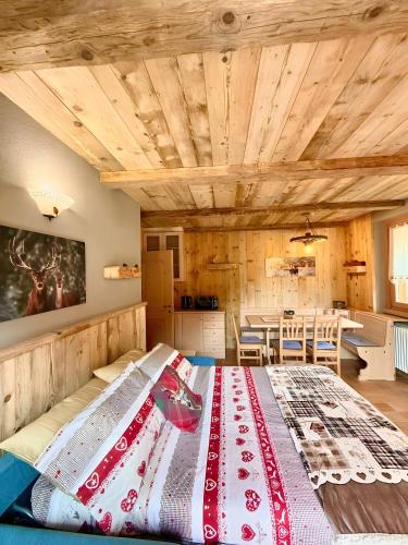 a large bed in a room with wooden ceilings at Casa Clus Bormio apartments 3 in Valdisotto