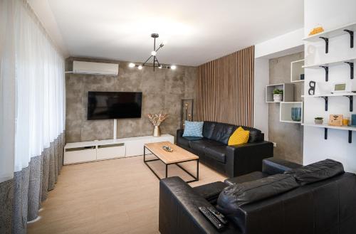 a living room with a couch and a tv at Central Park Apartment in Veliko Tŭrnovo