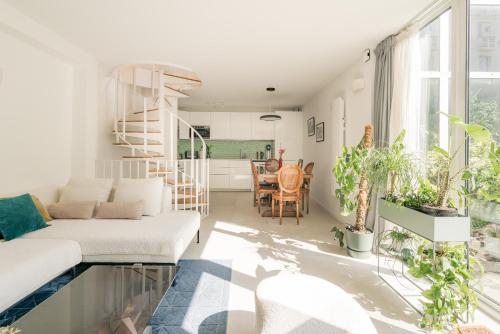 un salon avec un canapé blanc et des plantes dans l'établissement Veeve - Buttes Chaumont Maisonnette, à Paris