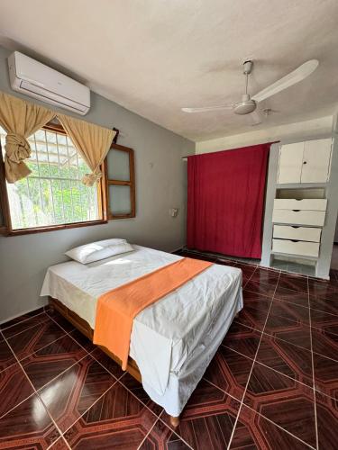 ein Schlafzimmer mit einem Bett und einem roten Vorhang in der Unterkunft Cabañas santamaria in Tulum