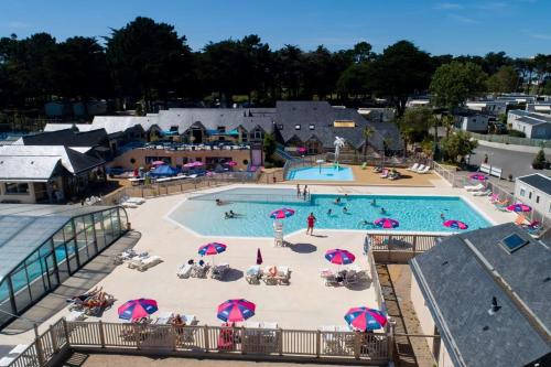 une vue aérienne d'une grande piscine avec des parasols dans l'établissement Mobil home 3 chambres 40 m2, à Quiberon