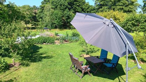 a table and two chairs and an umbrella at Domaine de la cure in Curgy