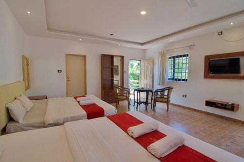 a hotel room with two beds and a living room at Golden Rice Resort & Cottages in Candolim