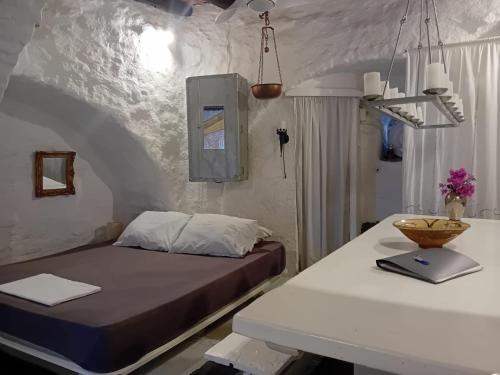 een slaapkamer met een bed en een witte tafel bij Villa Romantica in Parikia