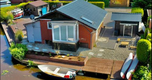 a model of a house with a boat in the water at Kleines Paradies an der Nordsee am Großen Meer in Südbrookmerland